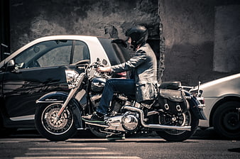 Man on Black Motorcycle Parked Between Cars