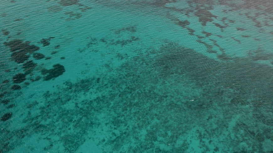 Aerial View of Turquoise Ocean Water with Coral Reef Textures