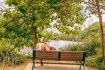 Woman Relaxing on Park Bench with City Skyline View