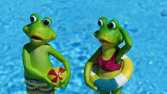 Cute cartoon frog statues by a swimming pool