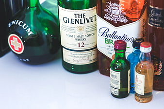 Assortment of whiskey and liquor bottles on white surface