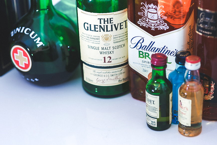 Assortment of whiskey and liquor bottles on white surface
