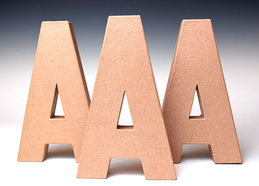 Three wooden letter A blocks on white background
