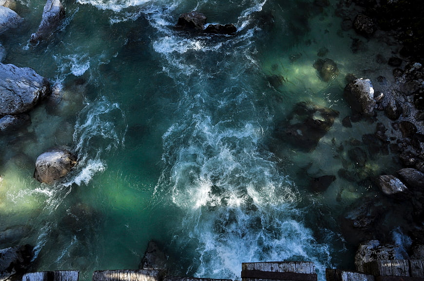Aerial view of turquoise ocean waves crashing against rocky coast