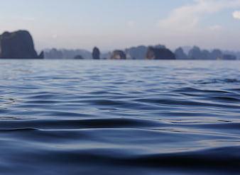 Calm Blue Ocean Water with Blurred Islands in Background