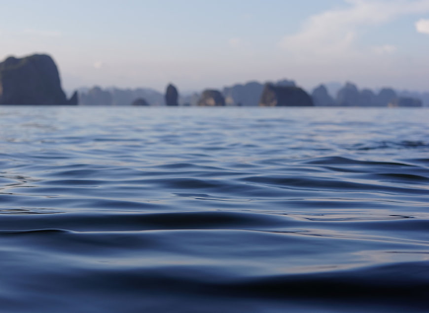 Calm Blue Ocean Water with Blurred Islands in Background