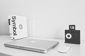 Minimalist black and white workspace with laptop and books