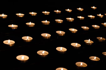 Rows of lit memorial candles glowing in the dark