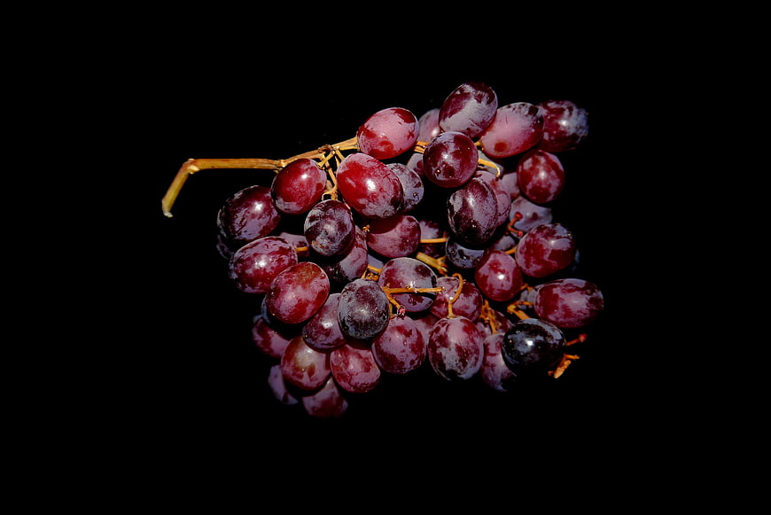 Cluster of Ripe Red Grapes on Black Background