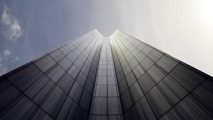 Low angle view of modern skyscraper against blue sky