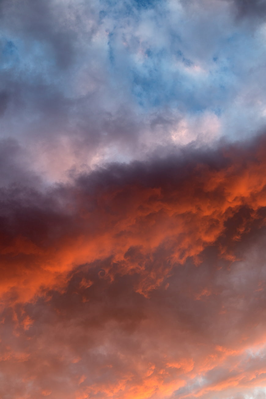 Dramatic fiery orange and blue sunset clouds sky
