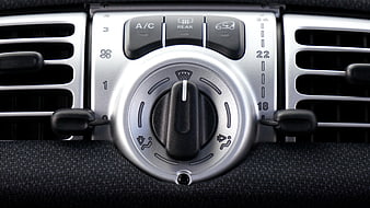 Close-up of car dashboard air conditioning controls and vents