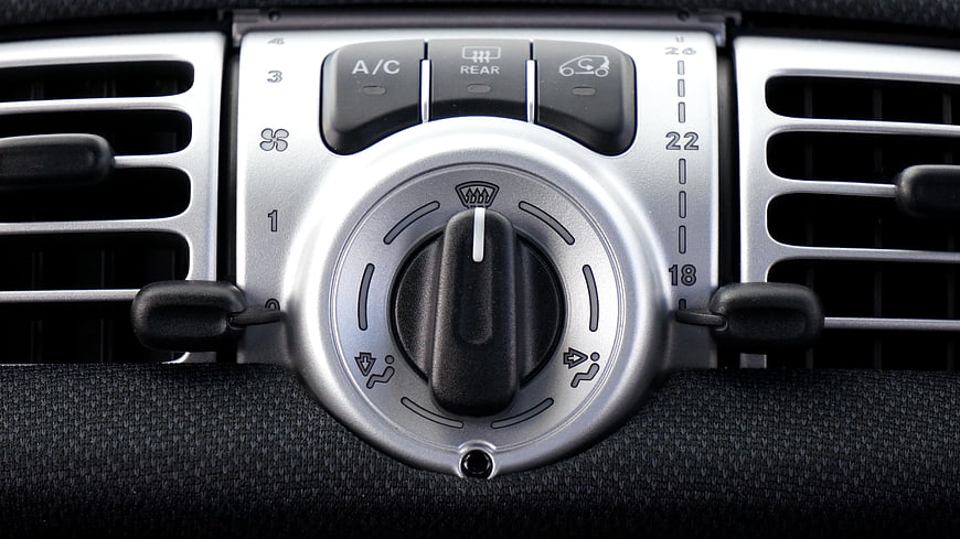 Close-up of car dashboard air conditioning controls and vents
