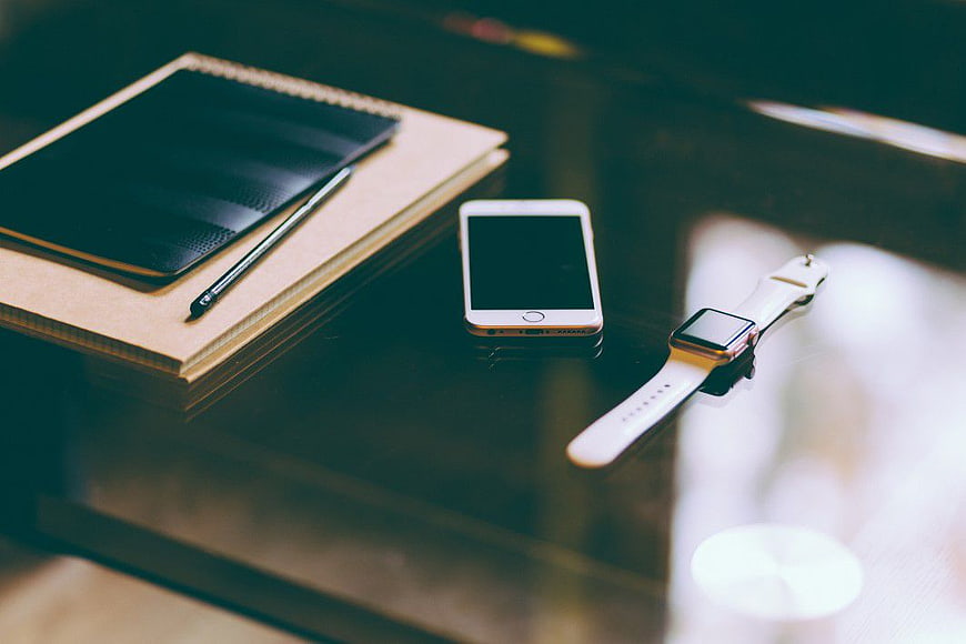 Smartphone, Smartwatch, and Notebook on Dark Desk