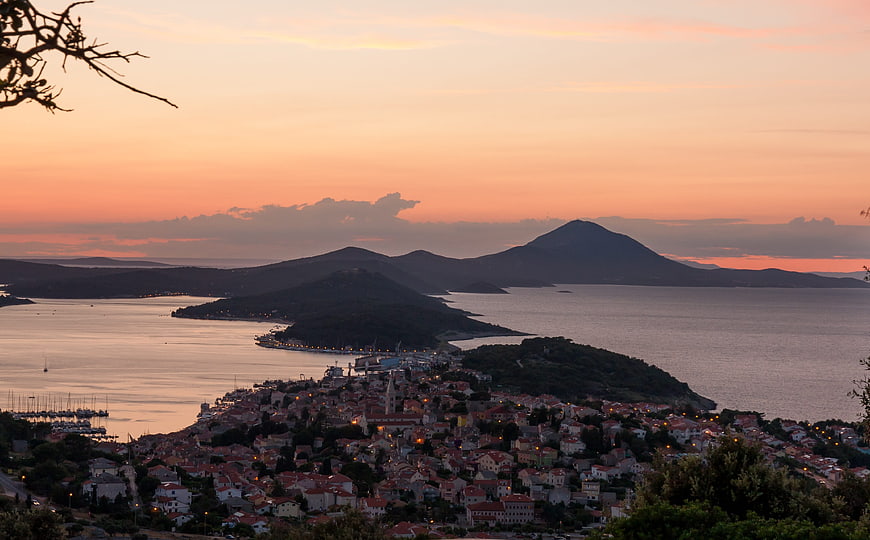 Sunset view of coastal town with mountains and sea