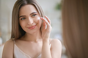 Young Woman Applying Skincare Cream to Face