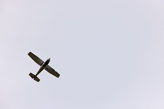 Small Propeller Airplane Flying Against Overcast Sky