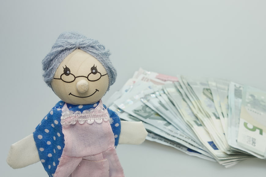 Wooden grandmother doll with euro banknotes for pension concept