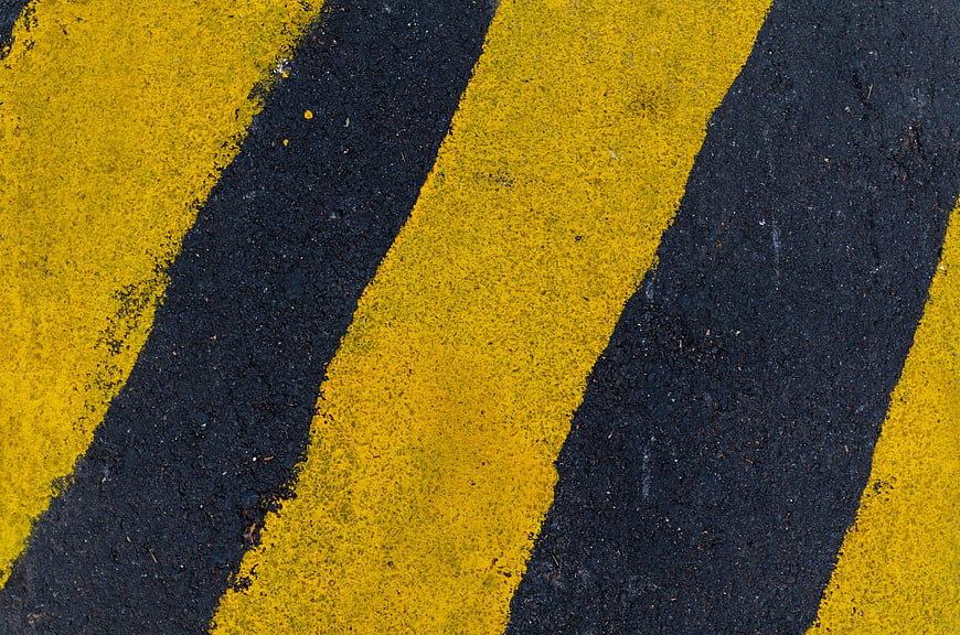 Yellow and Black Diagonal Stripes on Asphalt Texture