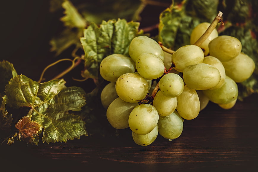 Fresh Green Grapes With Leaves On Dark Wooden Surface