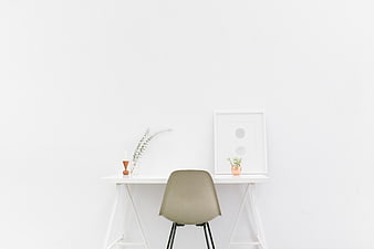 Minimalist white workspace with beige chair and decor