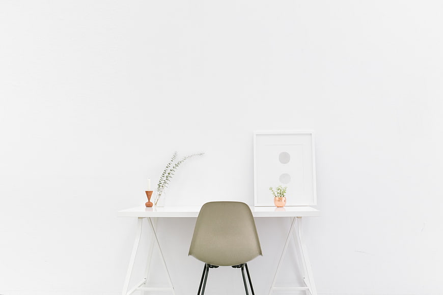Minimalist white workspace with beige chair and decor