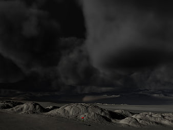 Lone Red Rose in Dark Desert Landscape Under Stormy Clouds