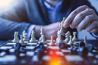 Close-up of hand moving chess king piece on board