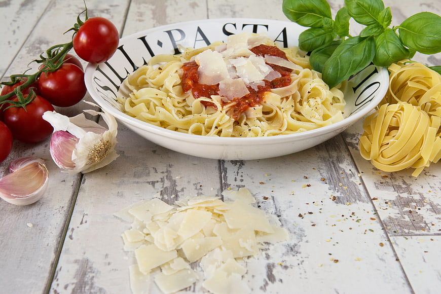 Fresh Pasta with Tomato Sauce and Basil on Rustic Table
