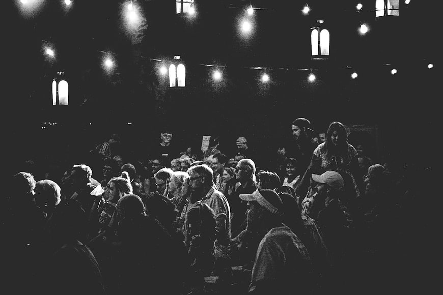 Black and white crowd at a dimly lit concert venue