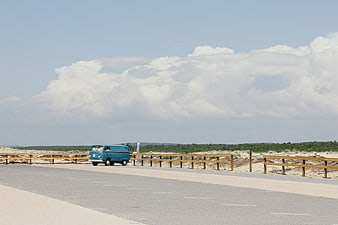 Blue Vintage Van on Coastal Road with Cloudy Sky