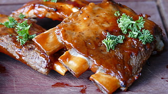 Glossy BBQ Pork Ribs with Parsley Garnish on Wooden Board