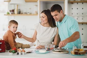 Happy family preparing breakfast together in modern kitchen