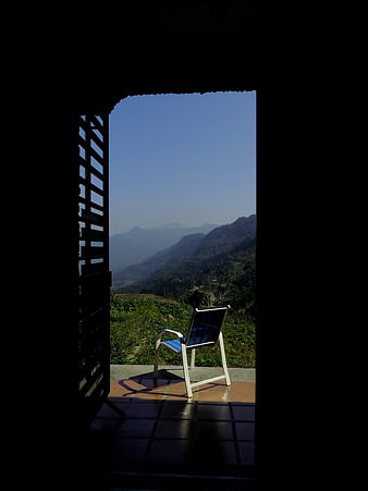 Empty Chair on Balcony Overlooking Mountain Range
