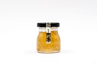 Glass jar of edible bird's nest soup with black lid on white background