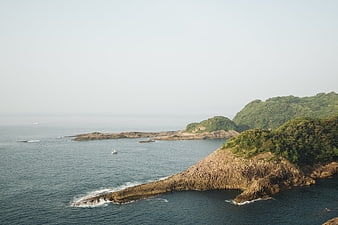 Aerial View of Rocky Coastal Peninsula with Lush Green Hills