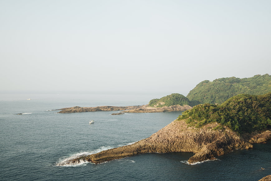 Aerial View of Rocky Coastal Peninsula with Lush Green Hills