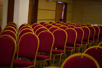 Rows of empty red chairs in a conference hall