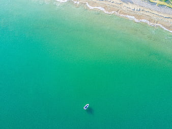 Aerial View of Turquoise Sea with Small Boat and Sandy Beach