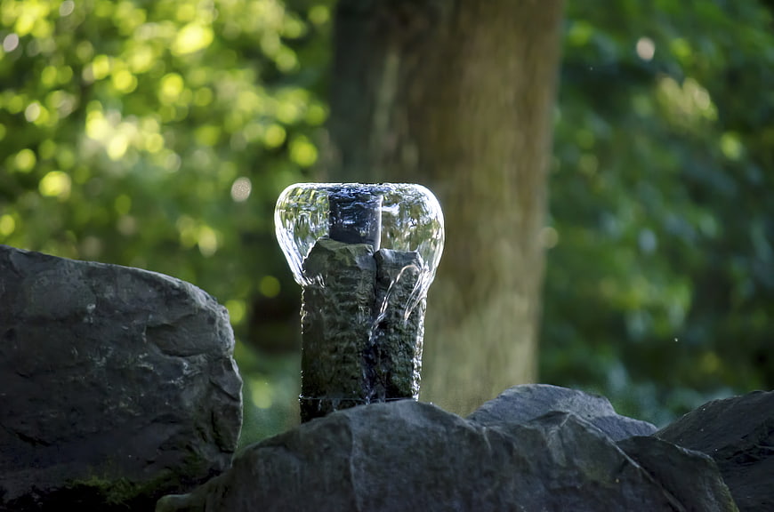 Water flowing over stone in a garden fountain