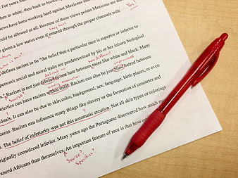 Red pen correcting essay on racism with handwritten notes