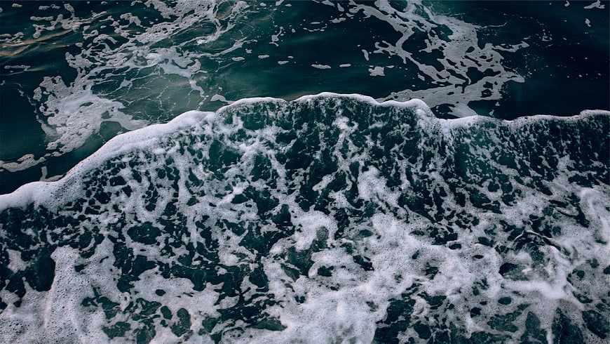 Aerial View of Dark Ocean Waves with White Sea Foam