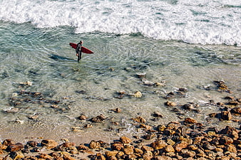 Surfer with Red Board Walking into Ocean Waves
