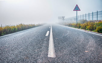 Foggy Highway Road With Roundabout Sign And Sound Barrier