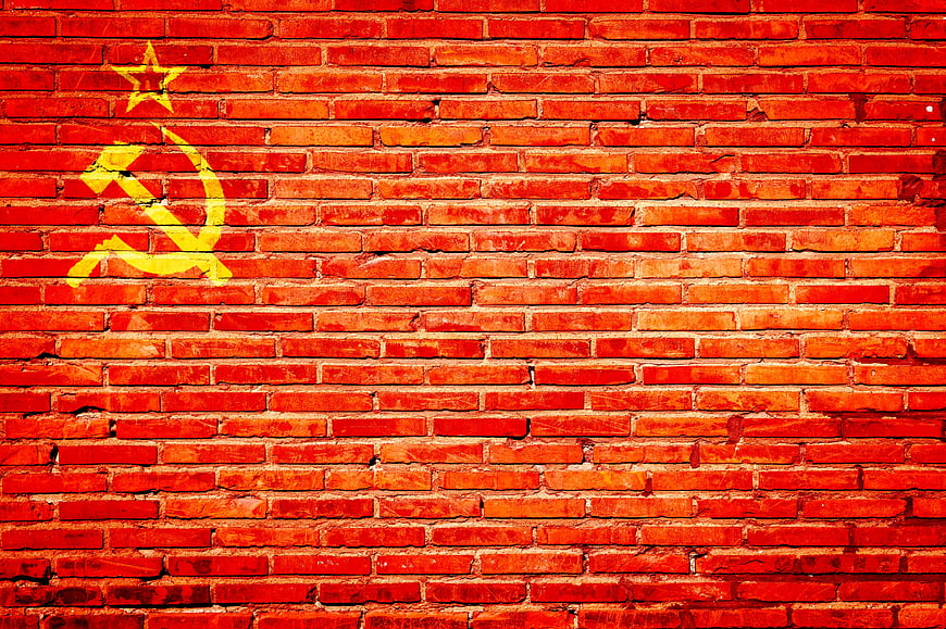 Yellow Soviet Hammer and Sickle Symbol on Red Brick Wall