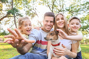 Happy family with dog taking selfie in park