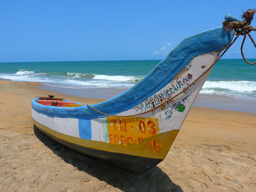 Colorful Fishing Boat on Sandy Beach with Ocean Waves