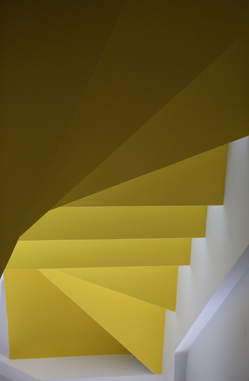 Abstract yellow spiral staircase with geometric shadows