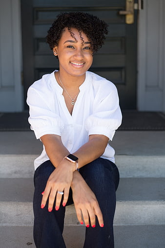 Smiling young woman sitting on outdoor steps
