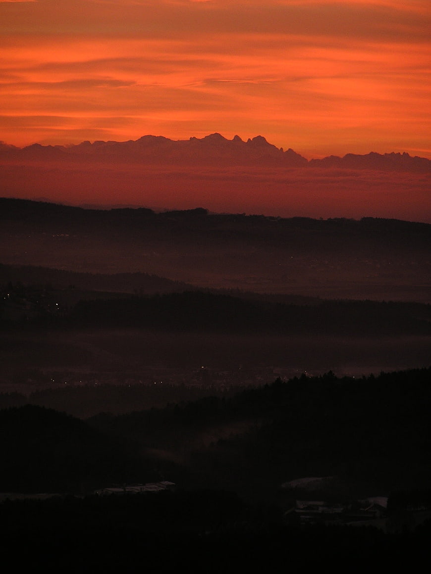 Dramatic Red Sunset Over Silhouetted Alpine Mountain Ranges
